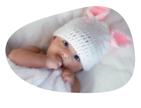 genderscreen small baby holding foot laying down in a crib